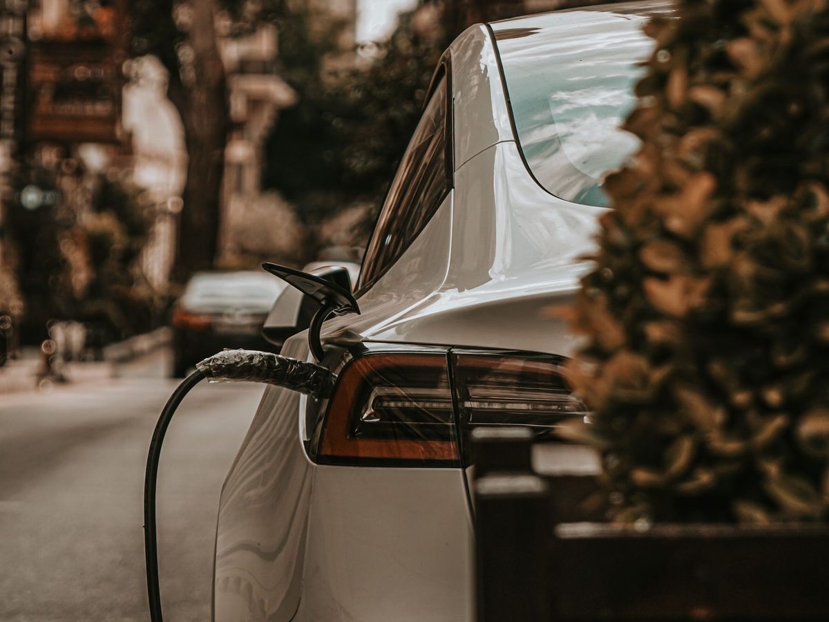 Auto eléctrico blanco cargando en la calle