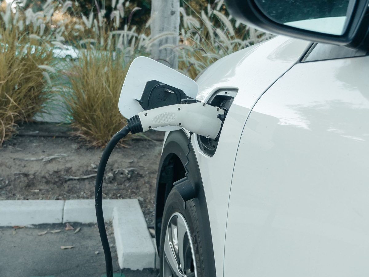 Auto eléctrico blanco conectado al cargador