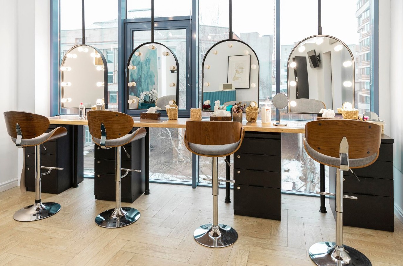 Salón de belleza con espejos con luces y banquetas de madera