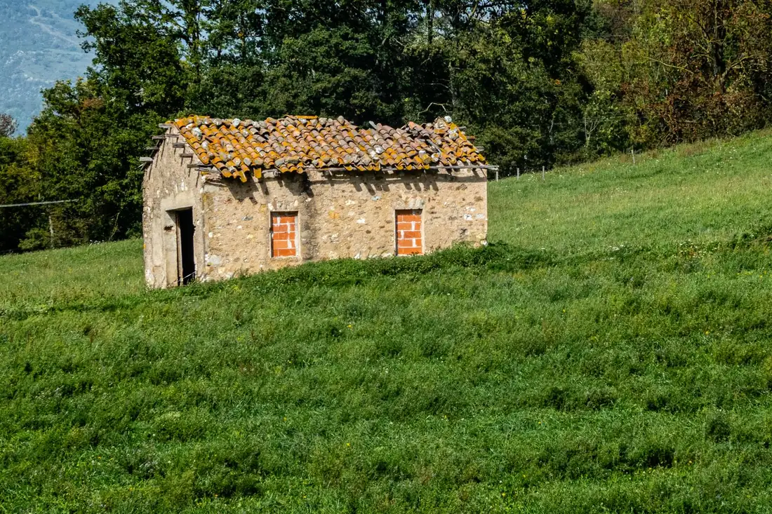 La Chacra: casita de piedra aislada sobre una loma de pasto verde