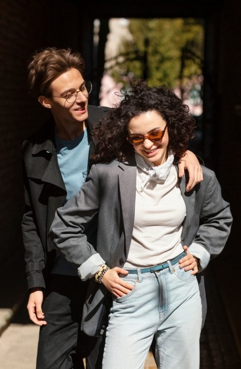 Pareja caminando por la calle con looks de la colección