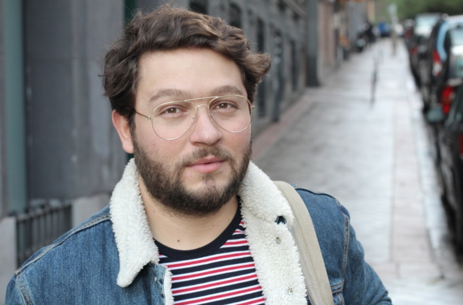 Hombre con campera de jean caminando por una vereda